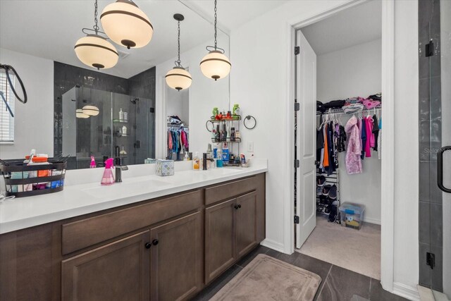 bathroom with vanity, baseboards, a walk in closet, and a shower stall