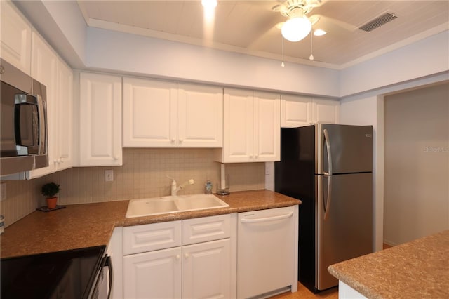 kitchen featuring tasteful backsplash, visible vents, white cabinets, appliances with stainless steel finishes, and a sink