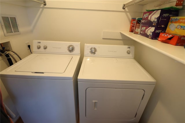 laundry room with laundry area, washing machine and dryer, and visible vents