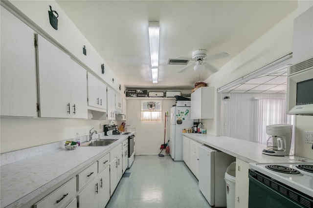 kitchen featuring light countertops, white appliances, visible vents, and a sink