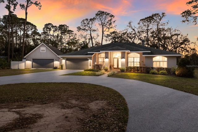 ranch-style house with concrete driveway, a yard, an attached garage, and stucco siding