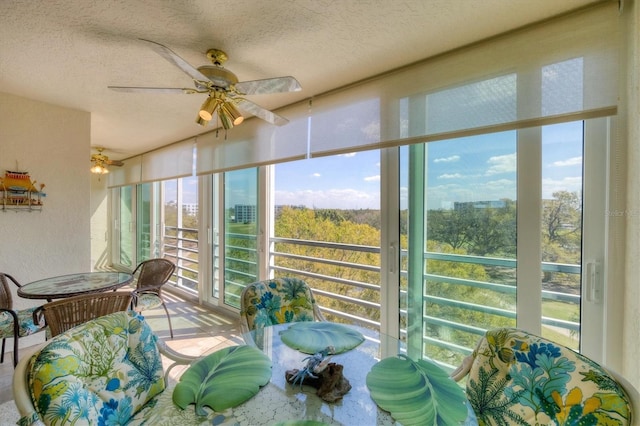 sunroom / solarium with a ceiling fan and a city view