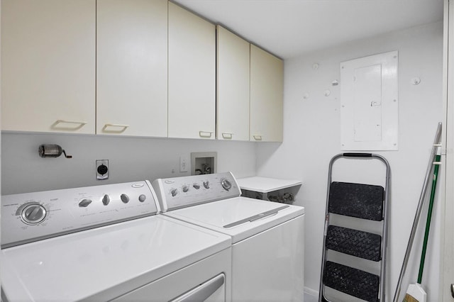 clothes washing area featuring washing machine and dryer, electric panel, and cabinet space