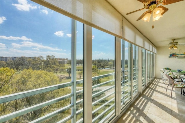 unfurnished sunroom featuring a ceiling fan