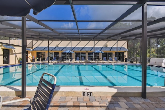 community pool featuring glass enclosure and a patio