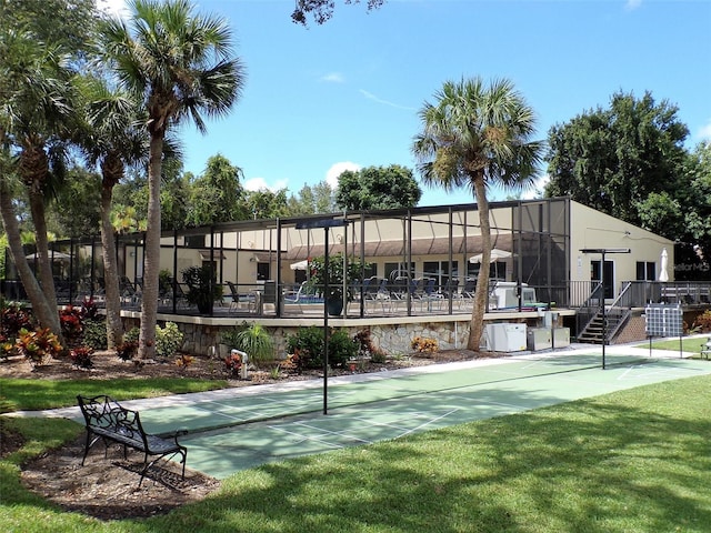 view of property's community featuring fence, shuffleboard, and a lawn