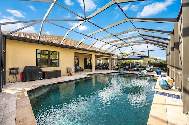 pool featuring a patio area, glass enclosure, and grilling area