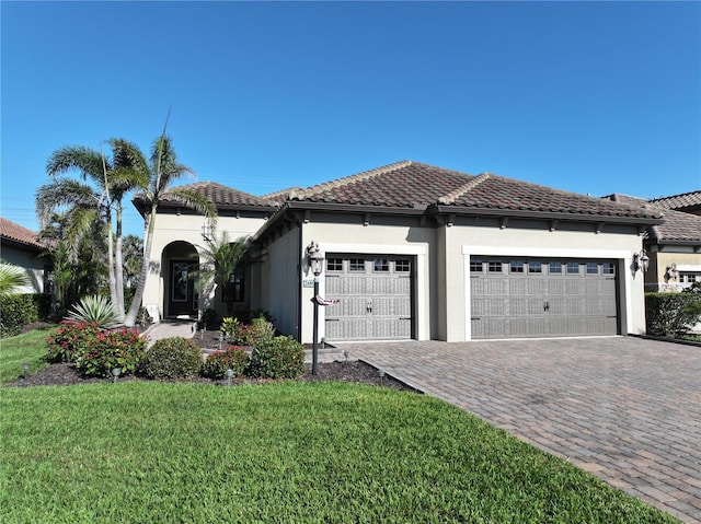 view of front of home with stucco siding, an attached garage, a tile roof, and decorative driveway