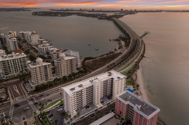 aerial view at dusk with a water view and a view of city