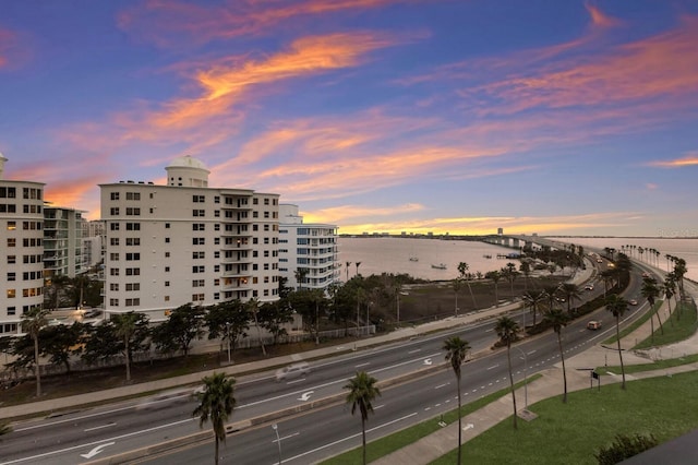 property at dusk featuring a water view