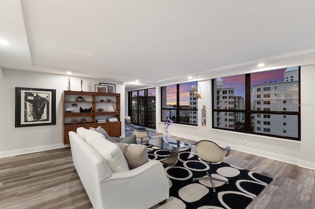 living area featuring a view of city, recessed lighting, baseboards, and wood finished floors