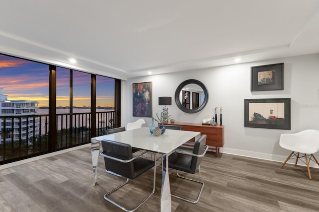 dining space with expansive windows, recessed lighting, wood finished floors, and baseboards