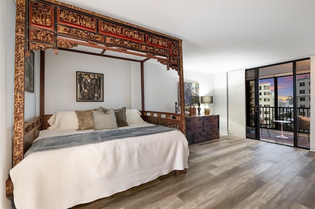 bedroom featuring access to outside, floor to ceiling windows, and wood finished floors