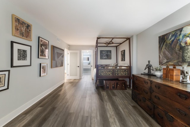 hallway with dark wood-style flooring, visible vents, and baseboards