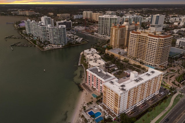 aerial view at dusk with a water view and a city view