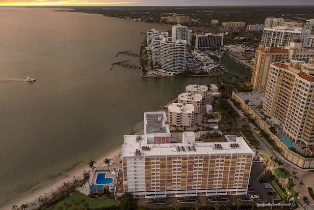 aerial view at dusk with a water view and a view of city