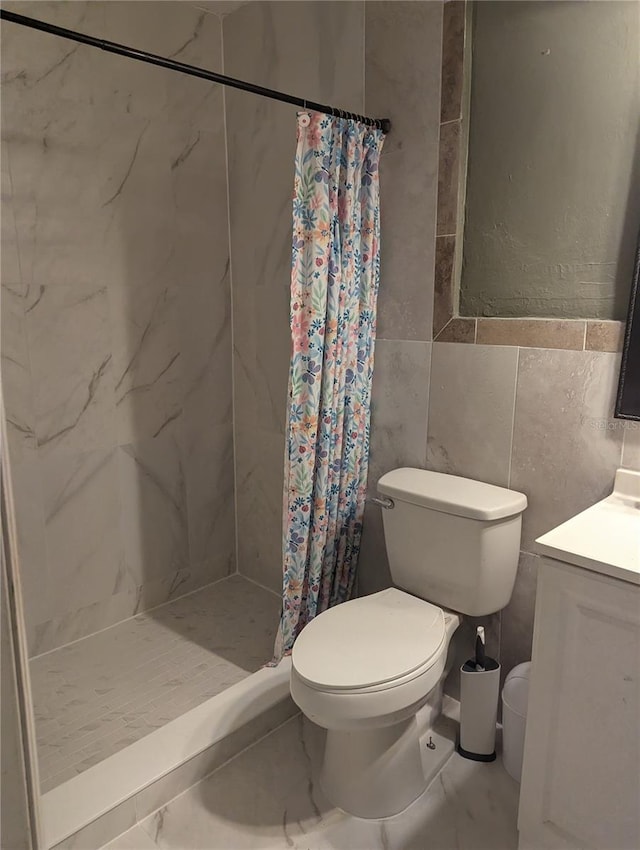 1807 48th Ave W, Bradenton, FL 34207 - bathroom featuring a shower stall, toilet, vanity, tile walls, and marble look tile flooring