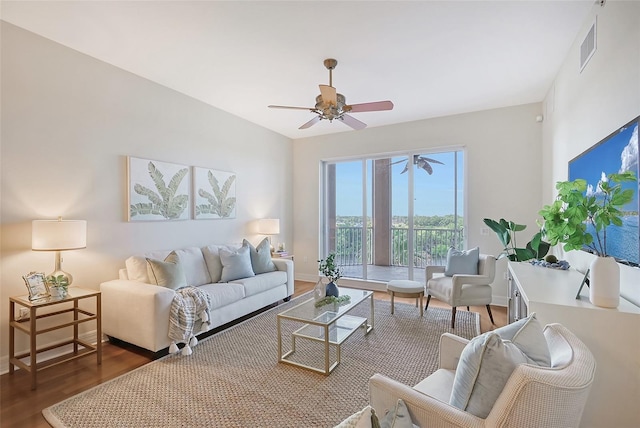 living area with a ceiling fan, visible vents, baseboards, and wood finished floors