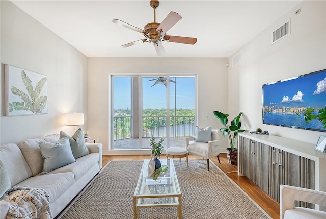 living area with a ceiling fan, visible vents, and light wood-style floors