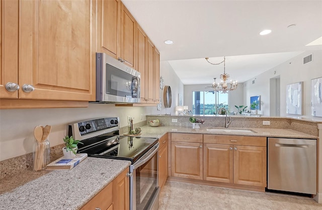 kitchen featuring a chandelier, light stone counters, stainless steel appliances, a sink, and visible vents