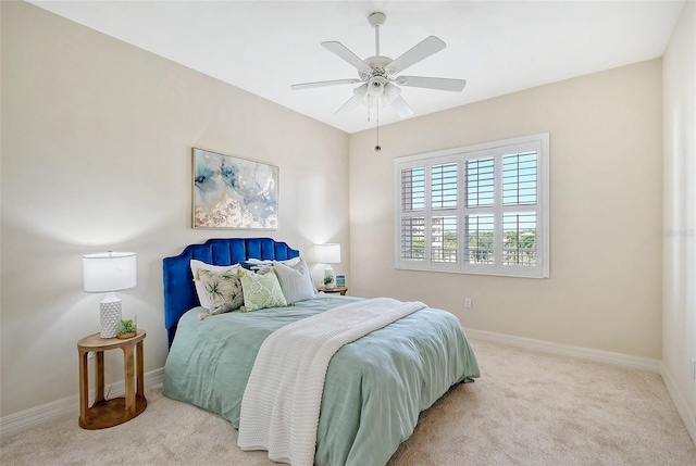 bedroom with light carpet, a ceiling fan, and baseboards