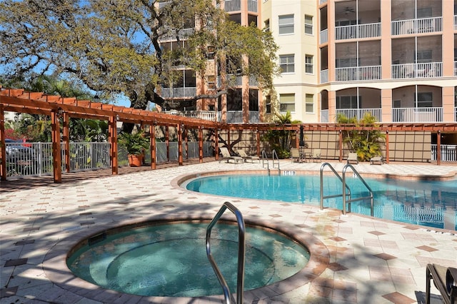 community pool featuring a pergola, a patio area, fence, and a hot tub