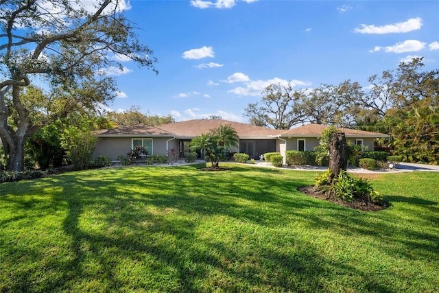 ranch-style home with a front yard and stucco siding