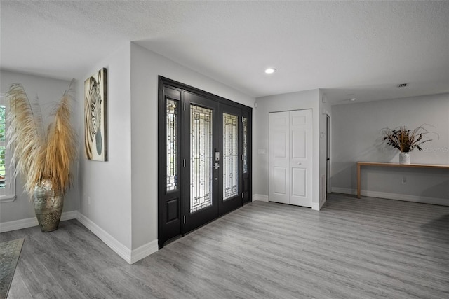 foyer entrance featuring a healthy amount of sunlight, baseboards, and wood finished floors