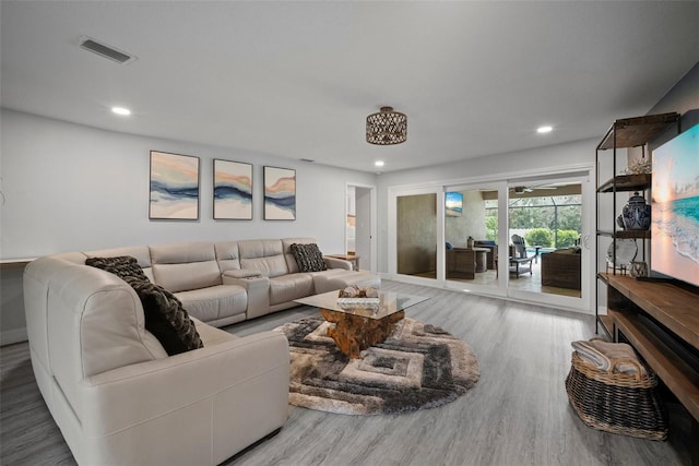 living room featuring recessed lighting, wood finished floors, and visible vents