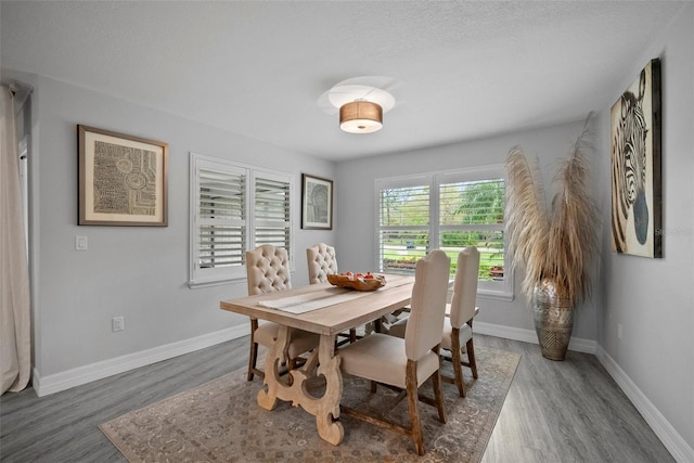 dining area with baseboards and wood finished floors