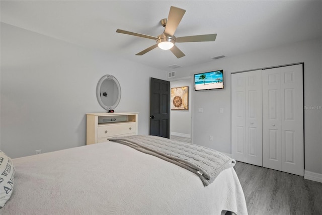 bedroom featuring a closet, visible vents, a ceiling fan, and wood finished floors