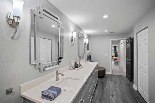 full bath with vanity, wood finished floors, baseboards, recessed lighting, and a closet