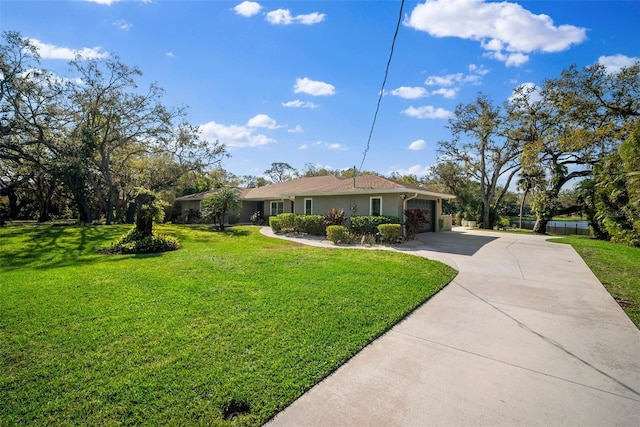 ranch-style home with stucco siding, an attached garage, concrete driveway, and a front lawn