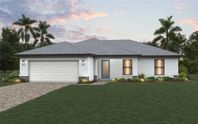 view of front of property featuring an attached garage, decorative driveway, a front yard, and stucco siding