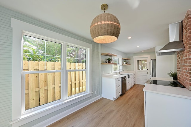 kitchen featuring white cabinets, appliances with stainless steel finishes, light countertops, wall chimney range hood, and open shelves