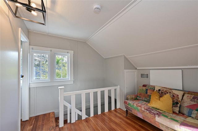 additional living space with visible vents, vaulted ceiling, and wood finished floors