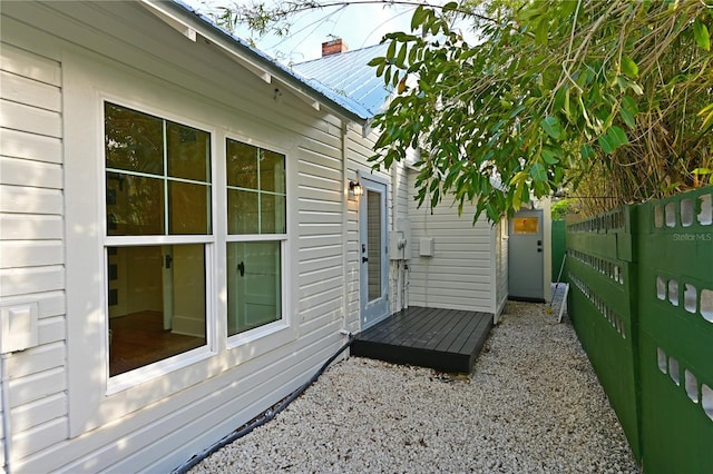 view of side of property featuring a fenced backyard and metal roof