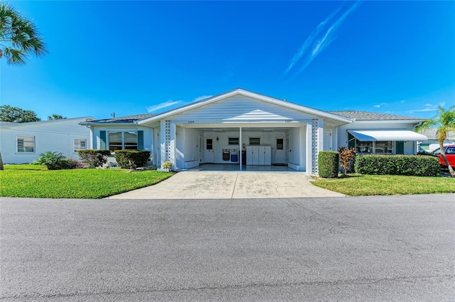 view of front of home featuring driveway, an attached carport, and a front yard