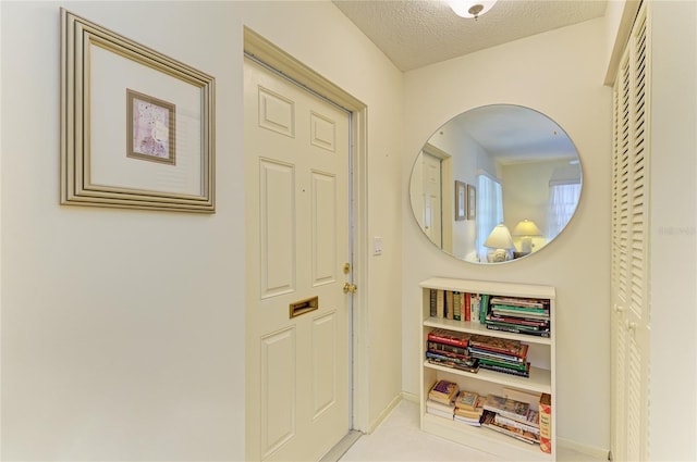 interior space with a textured ceiling, tile patterned flooring, and baseboards