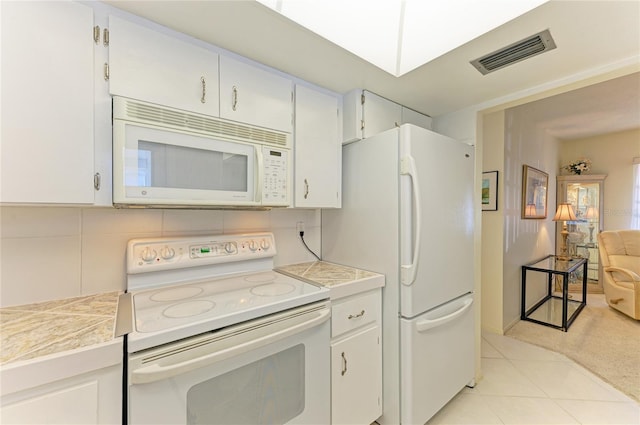 kitchen featuring white appliances, tasteful backsplash, visible vents, and light countertops