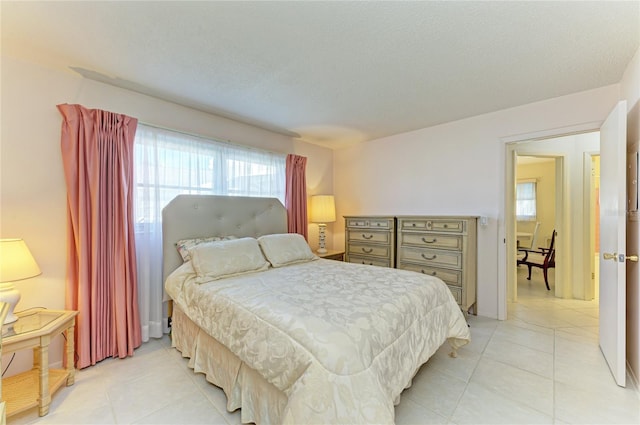 bedroom featuring light tile patterned floors and a textured ceiling