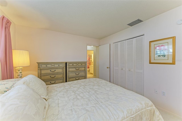 bedroom featuring a closet, visible vents, and a textured ceiling