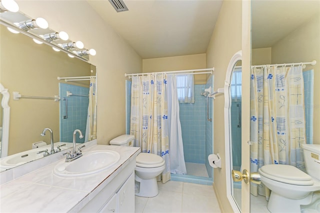 bathroom with visible vents, toilet, a stall shower, vanity, and tile patterned flooring