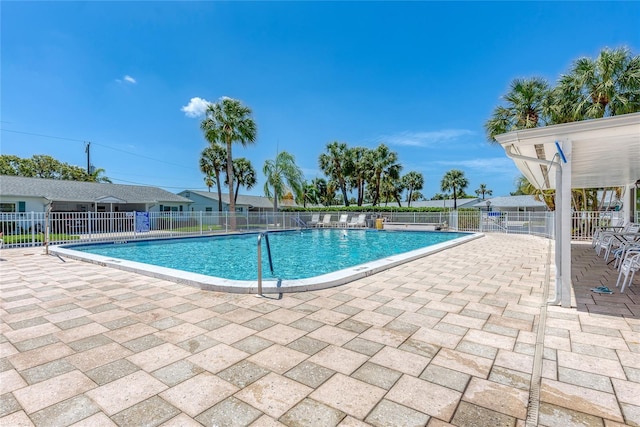 pool with a patio area and fence