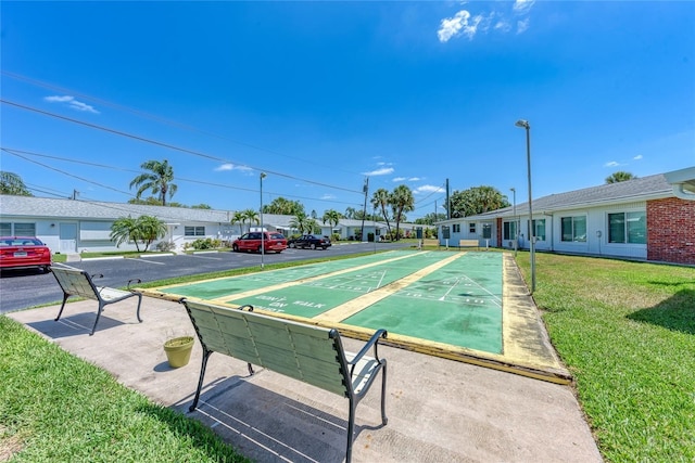 surrounding community featuring shuffleboard and a lawn