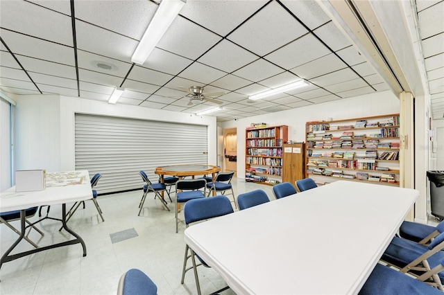 dining space featuring ceiling fan and a drop ceiling