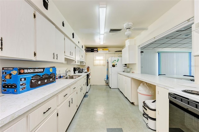 kitchen with ceiling fan, electric range, a sink, white cabinetry, and light countertops