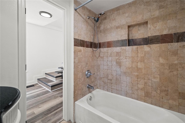 bathroom featuring wood finished floors, visible vents, and shower / bathtub combination