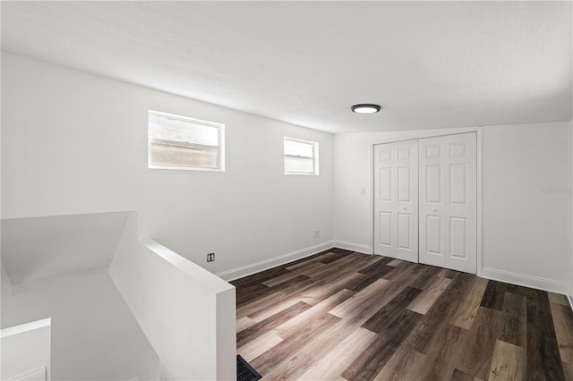 unfurnished bedroom featuring a closet, wood finished floors, and baseboards