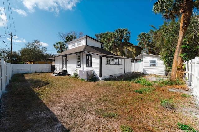 view of home's exterior featuring entry steps, a yard, an outdoor structure, and a fenced backyard